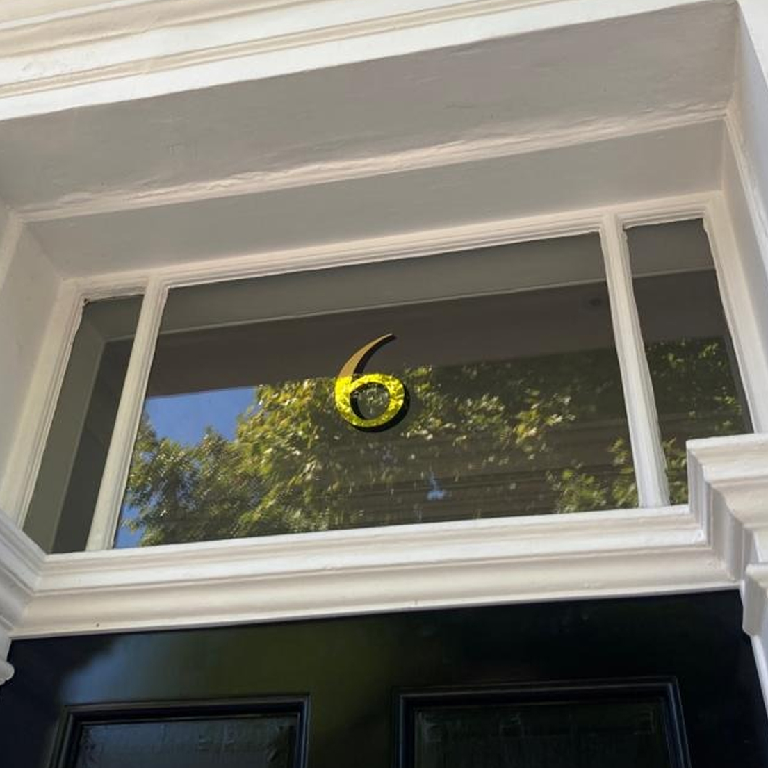 The number 6 in gilded gold leaf on a fanlight by NGS signwriters in London