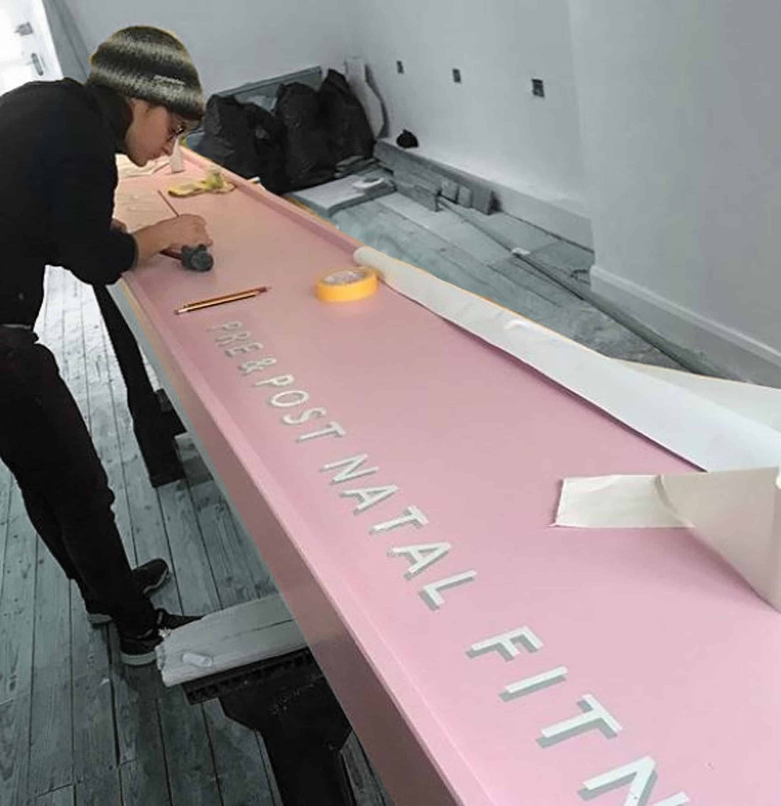 Seraina painting shop sign in studio, signage NGS, NGS Team signwriters London Mission statements, office, Mall, Gym sign writing murals